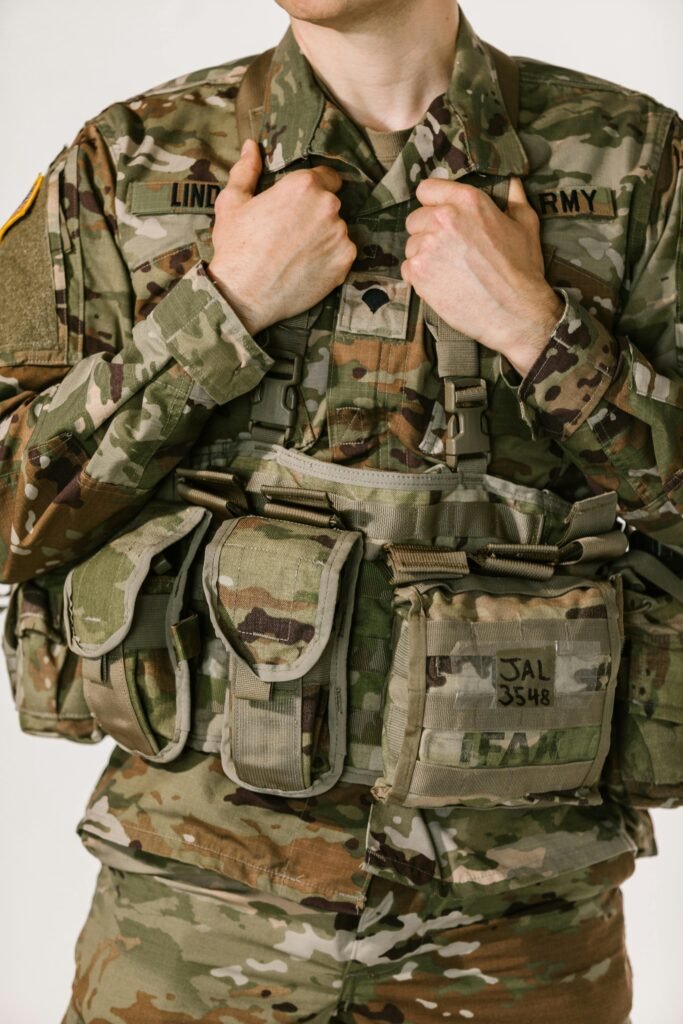 Close-up of soldier in camouflage with tactical gear on white background.